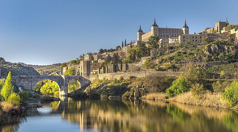 Bridge and river in Toledo, Spain with the Alcazar fortification in background