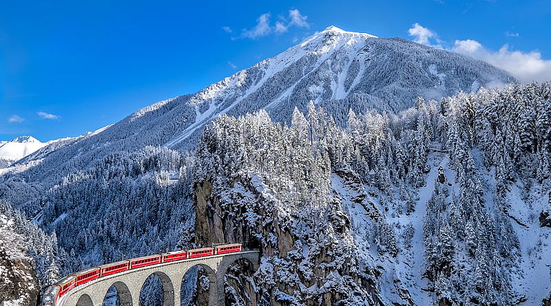 Glacier Express train traveling through the Alps in Switzerland