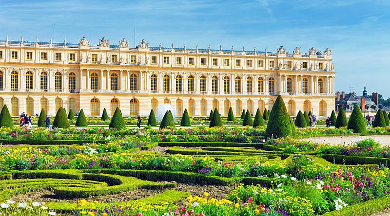 Lush green garden and Versailles building in France