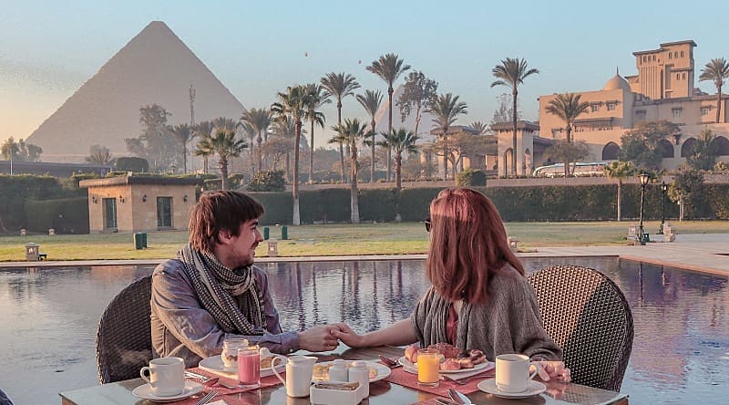 Cairo, Egypt Couple enjoying breakfast with a view over the Pyramids of Giza in Egypt