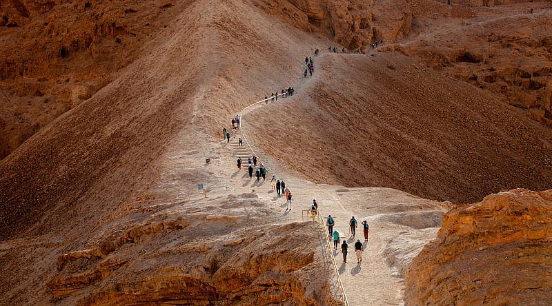 Tourist walking on Masada Fortress Rock in Israel Tourist walking on Masada Fortress Rock in Israel