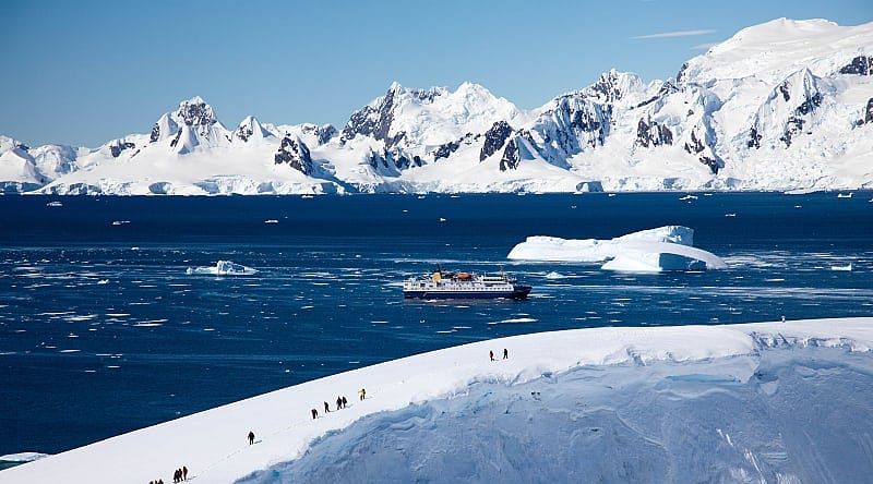 Antarctica Cruise and Excursion Tourists hiking on glacier during an excursion in Antarctica