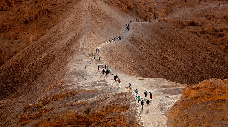 Tourist walking on Masada Fortress Rock in Israel Tourist walking on Masada Fortress Rock in Israel