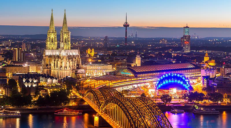 Night view of the Cologne Cathedral and the Hohenzollern bridge with the Rhine river in Germany.