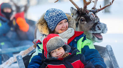 Family on reindeer safari in Finland.