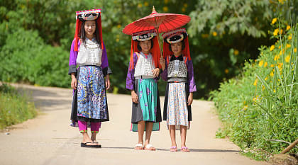 Three young Lahu Tribe girls in custom dress, smiling among the sunlight in Thailand. Three young Lahu Tribe girls in custom dress, smiling among the sunlight in Thailand.
