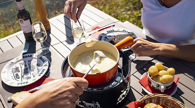 Fondue on the Moleson in Gruyères. Photo courtesy of Switzerland Tourism / Nicola Fuerer Two women enjoy a fondue on the Moleson in Gruyères, Switzerland