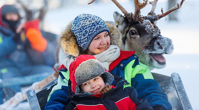 Family on reindeer safari in Finland.