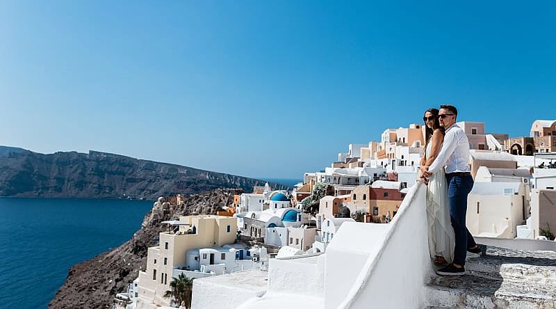 Couple enjoying the view of Santorini Island in Greece