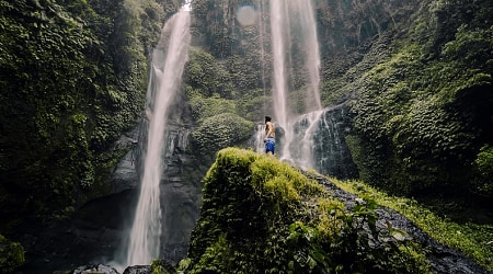 Traveler looking up at Sekempul Waterfall in Bali
