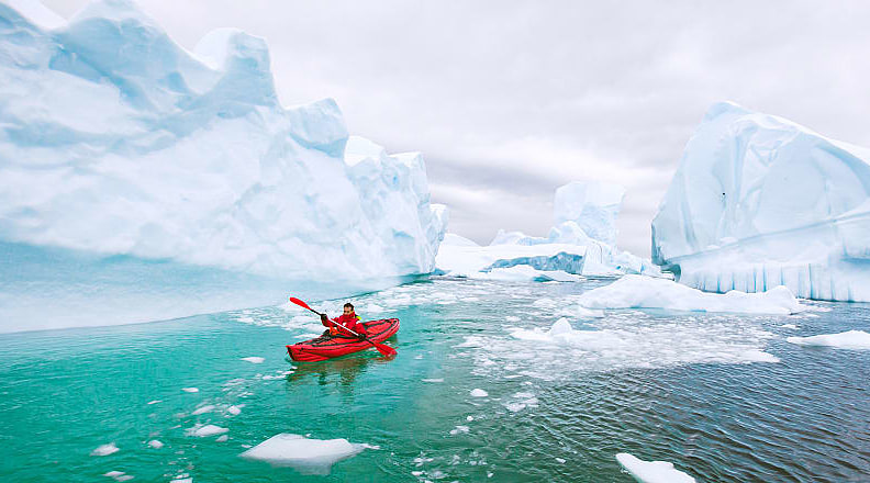 Kayaking around icebergs in Antarctica
