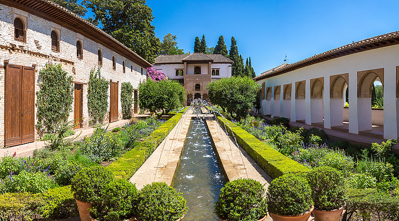 Garden and bell tower at Alhambra Palace in Granada in a beautiful summer day, Spain