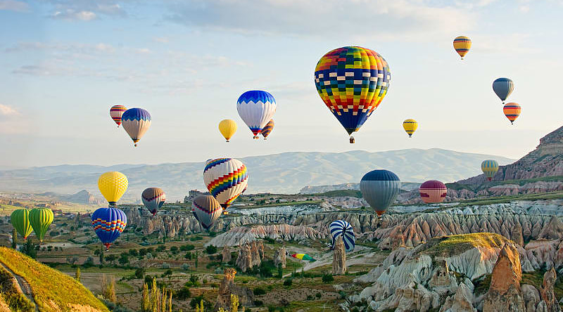 Colorful balloons fly over the Cappadocia valley in Turkey