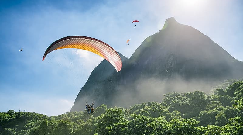 Couple on a romantic paragliding flight over the coast of Brazil