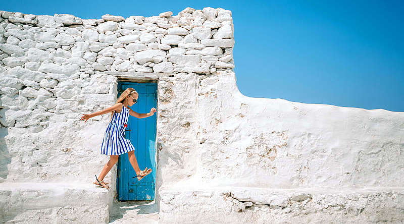 Little girl playing by Paraportiani church in Mykonos, Greece