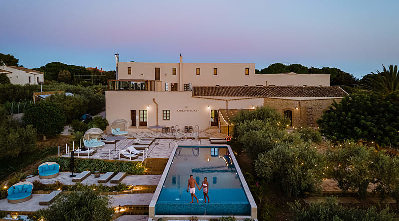 Couple at a luxury resort pool surrounded by vineyards in Selinunte, Sicily