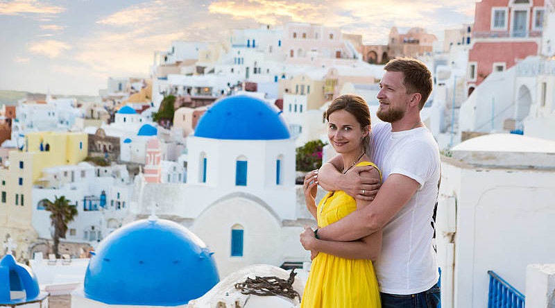 Couple enjoying the view of Santorini Island in Greece