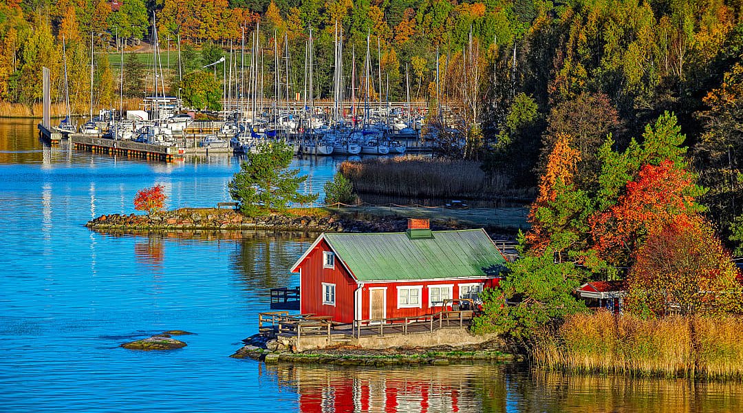 Red cabin and autumn forest on rocky shore of Ruissalo island, Turku Archipelago, Finland