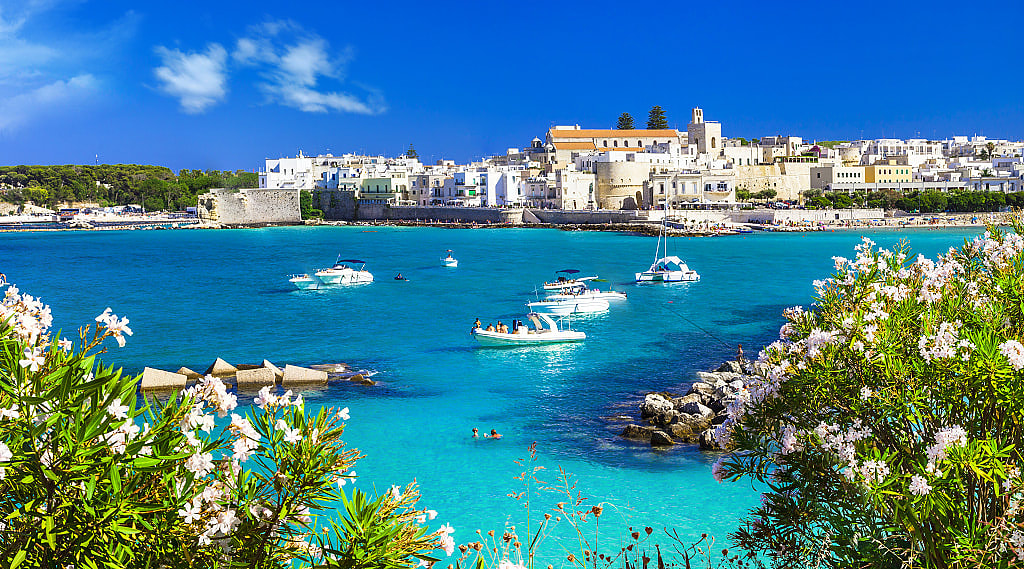 Boats in the crystal blue waters of Otranto in Puglia, Italy.