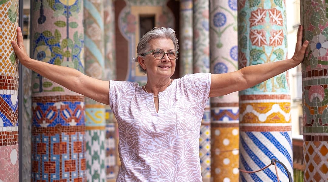 Senior traveler standing between colorful pillars at Palau de la Música Catalana in Barcelona, Spain