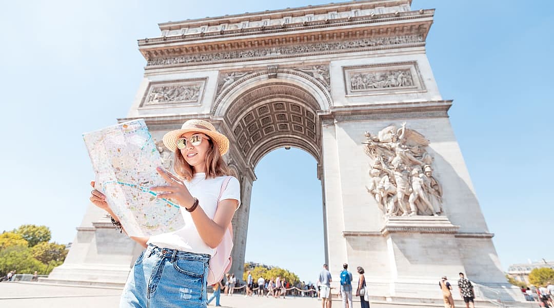 Tourist with Arch de Triomphe in the background in Paris, France