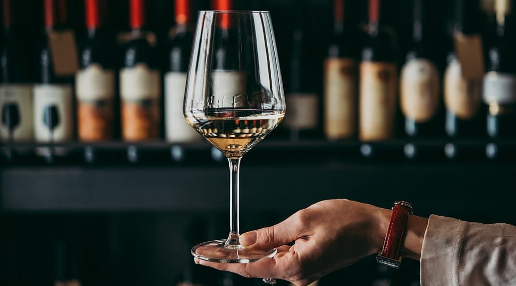 Woman holding wine glass showing the legs