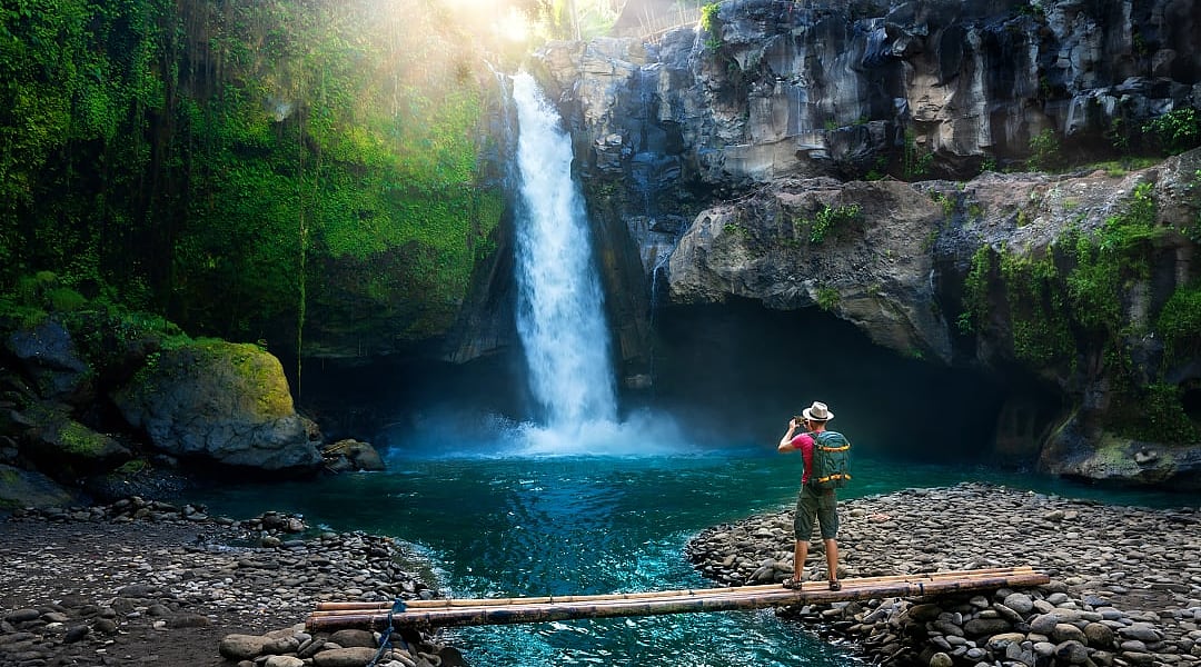 Hiker enjoying a waterfall in Bali, Indonesia