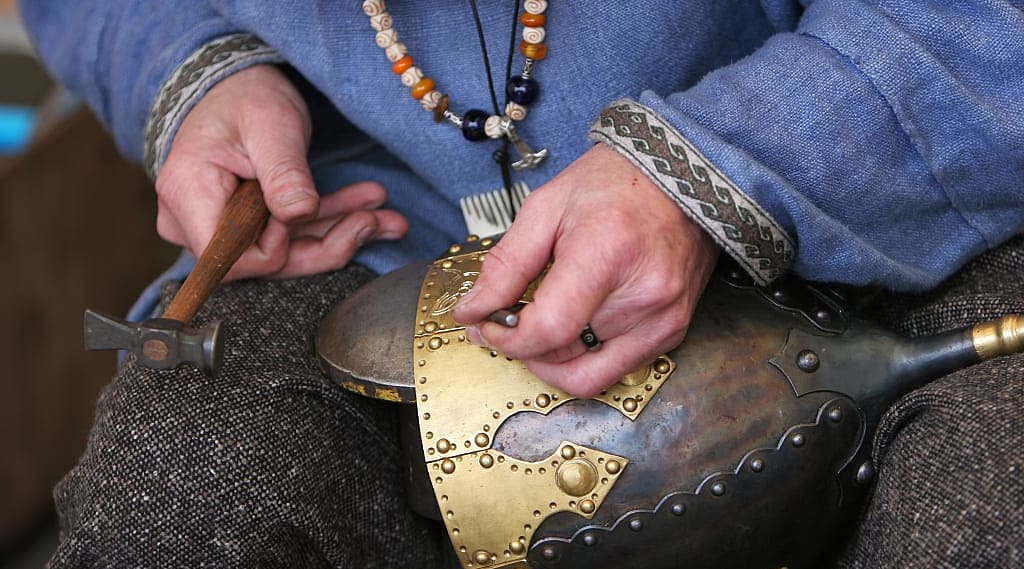 metal craftsman making a medieval soldiers helmet armor the old fashioned way
