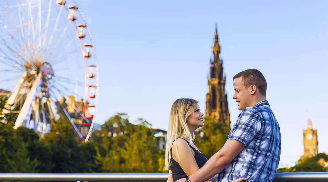 Couple with ferris wheel and Scott Monument in the background