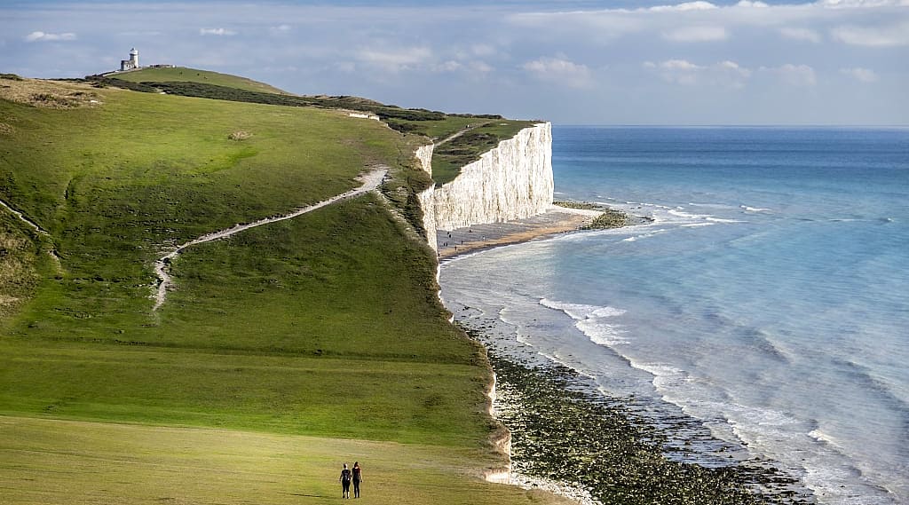 Couple walking on the Seven Sisters Chalk Cliffs on the South Coast of England