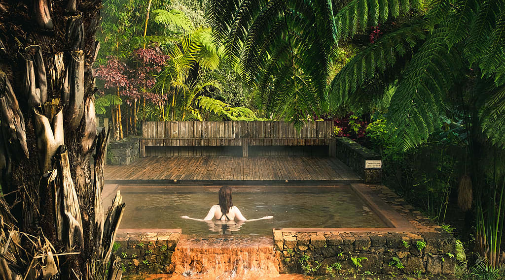 Female tourist enjoying hot springs pool at Poca da Dona Beija on Sāo Miguel, Azores