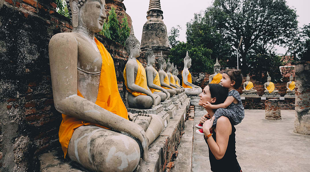 Mother and daughter looking at statues of Buddha in Ayutthaya, Thailand