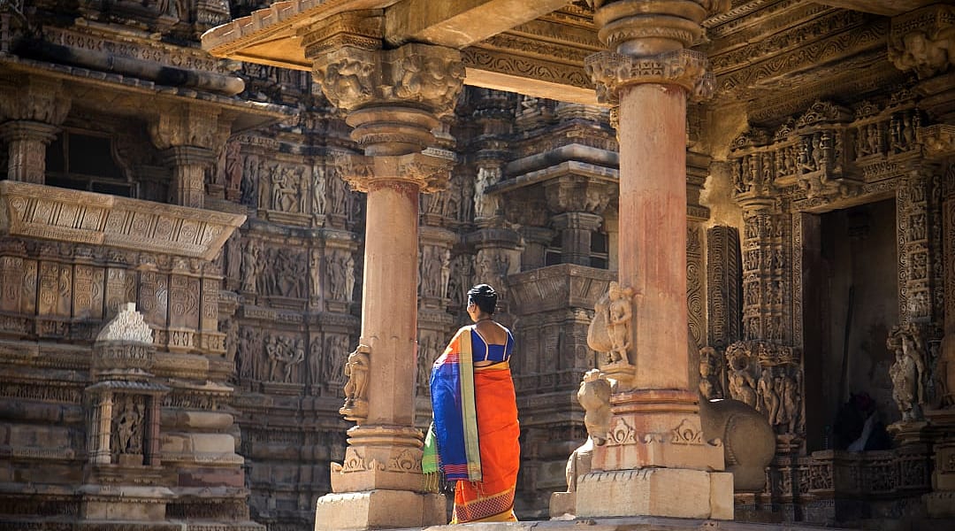 Indian women in colorful saree at Khajuraho Temple, UNESCO World Heritage Site, India.
