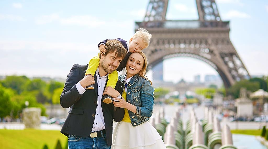 Happy family of three having fun together in Paris near the eiffel tower