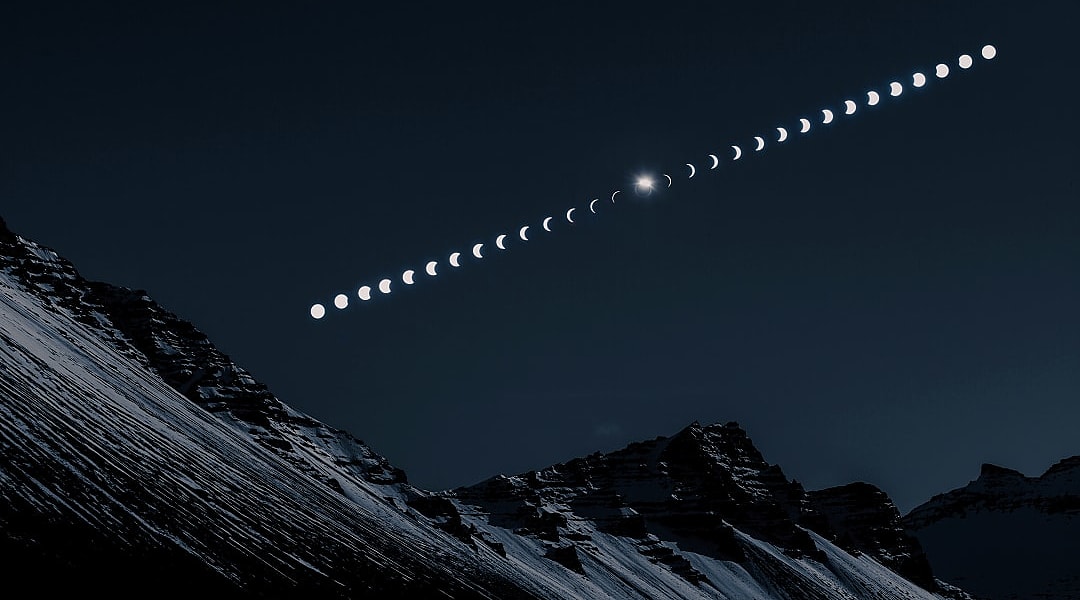 Composite image showing the phases of a solar eclipse over snow-covered mountain peaks at night.