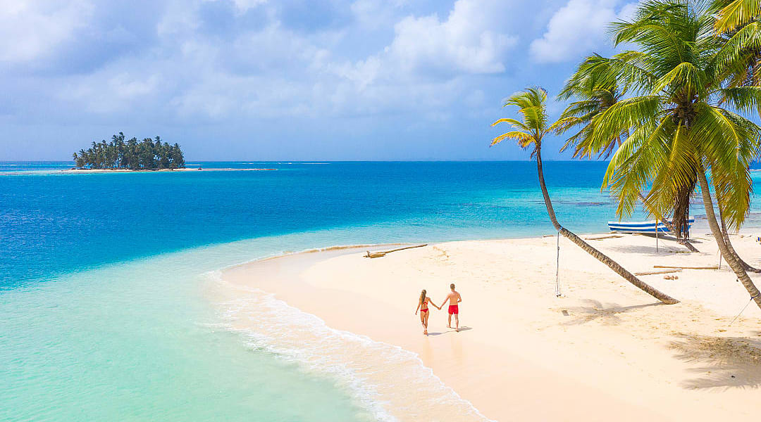 Couple walking hand-in-hand along the beach on San Blas island, Panama