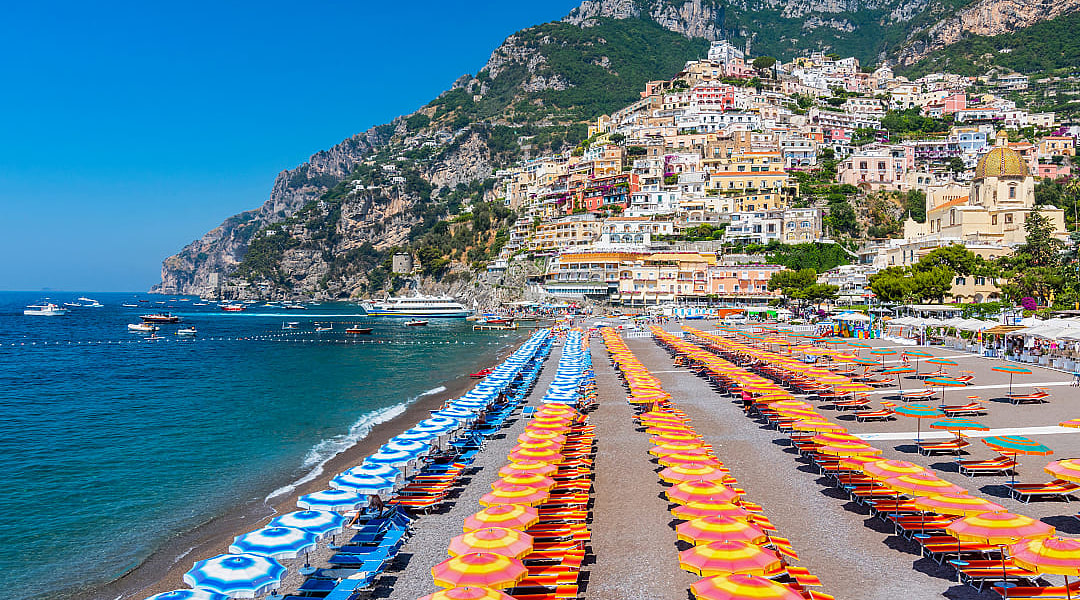 Orange and blue umbrellas on the beach in Positano on the Amalfi Coast of Italy
