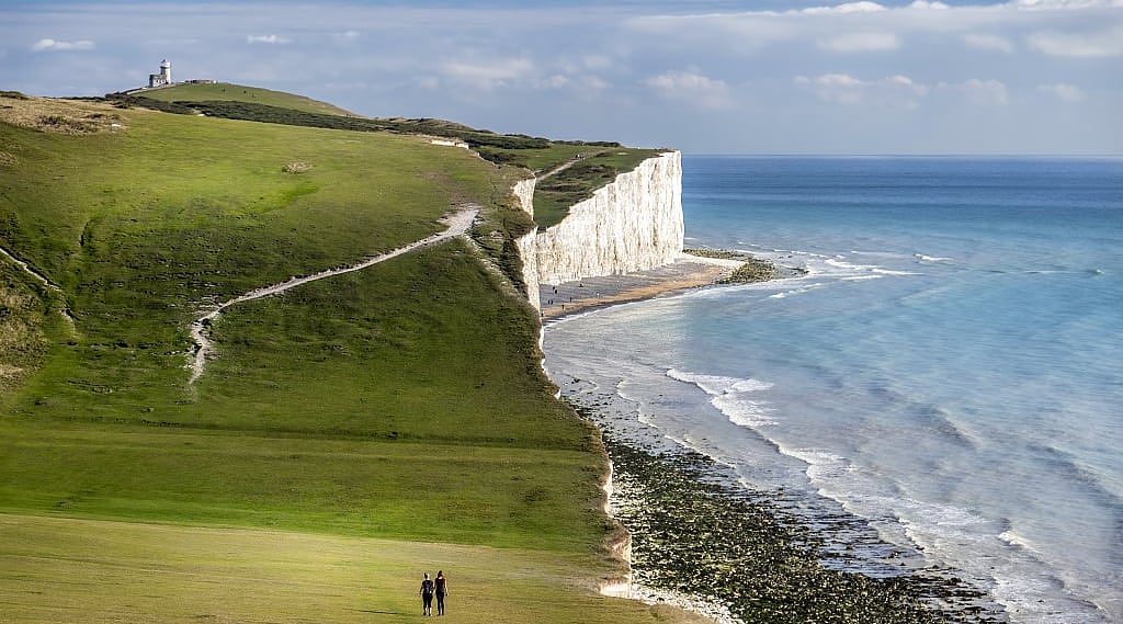 Couple walking on the Seven Sisters Chalk Cliffs on the South Coast of England