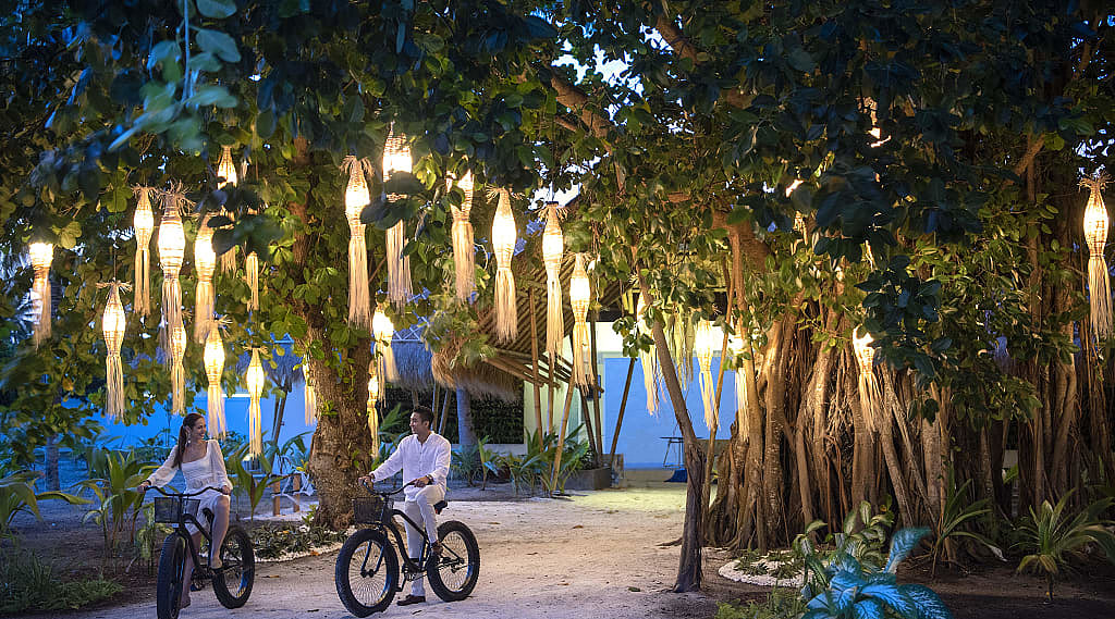 Couple fat biking around Fasmedhoo Island in the Maldives