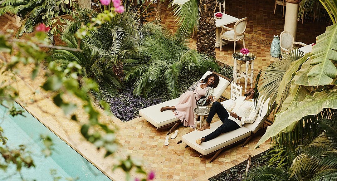 Couple at lounging by the pool at luxury riad in Marrakech, Morocco