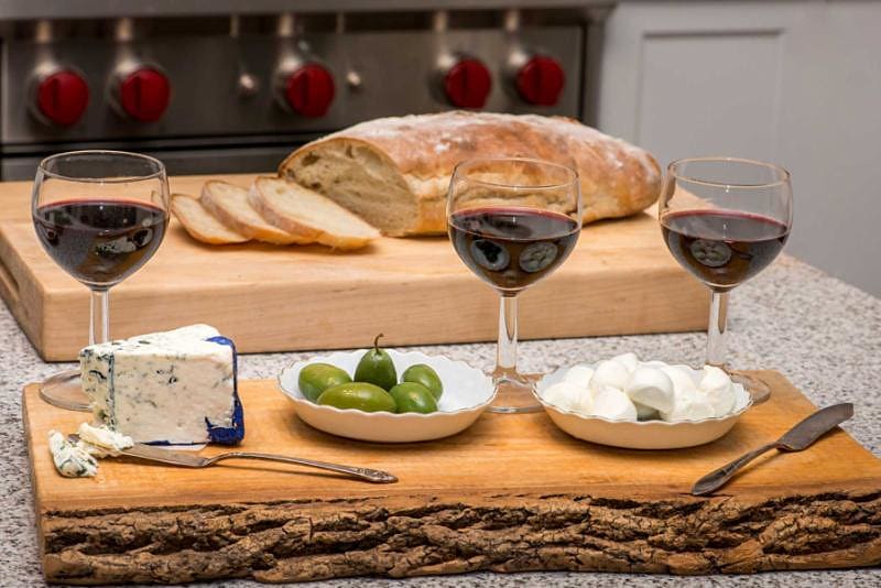 Sicilian setting - wine glasses, olives, blue cheese, bocconcini and ciabatta.