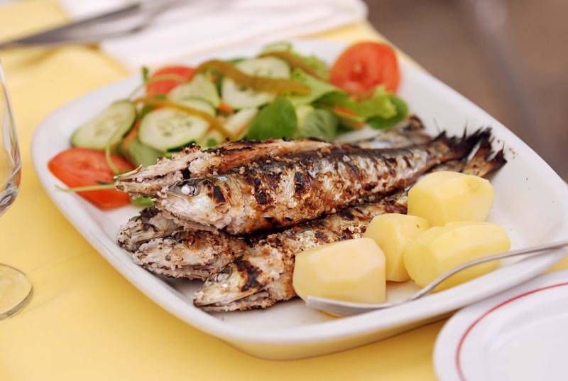 Famous grilled Portuguese sardines with potatoes and salad