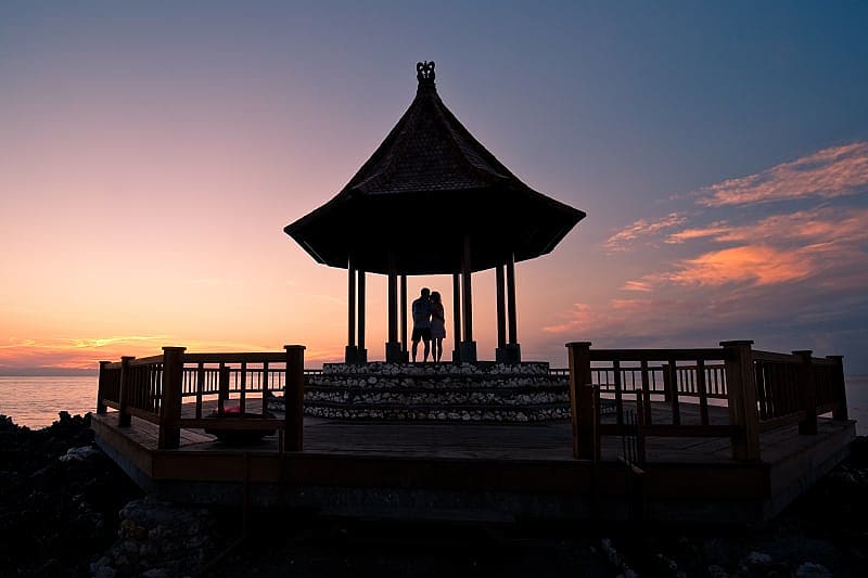 Silhouette of couple enjoying romantic sunset in Bali