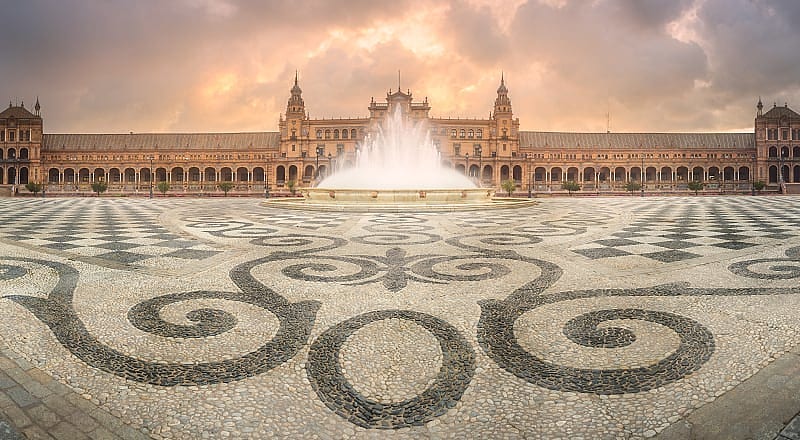 view of spain square seville with mosaic in foreground and cloud sky, andalusia, spain.