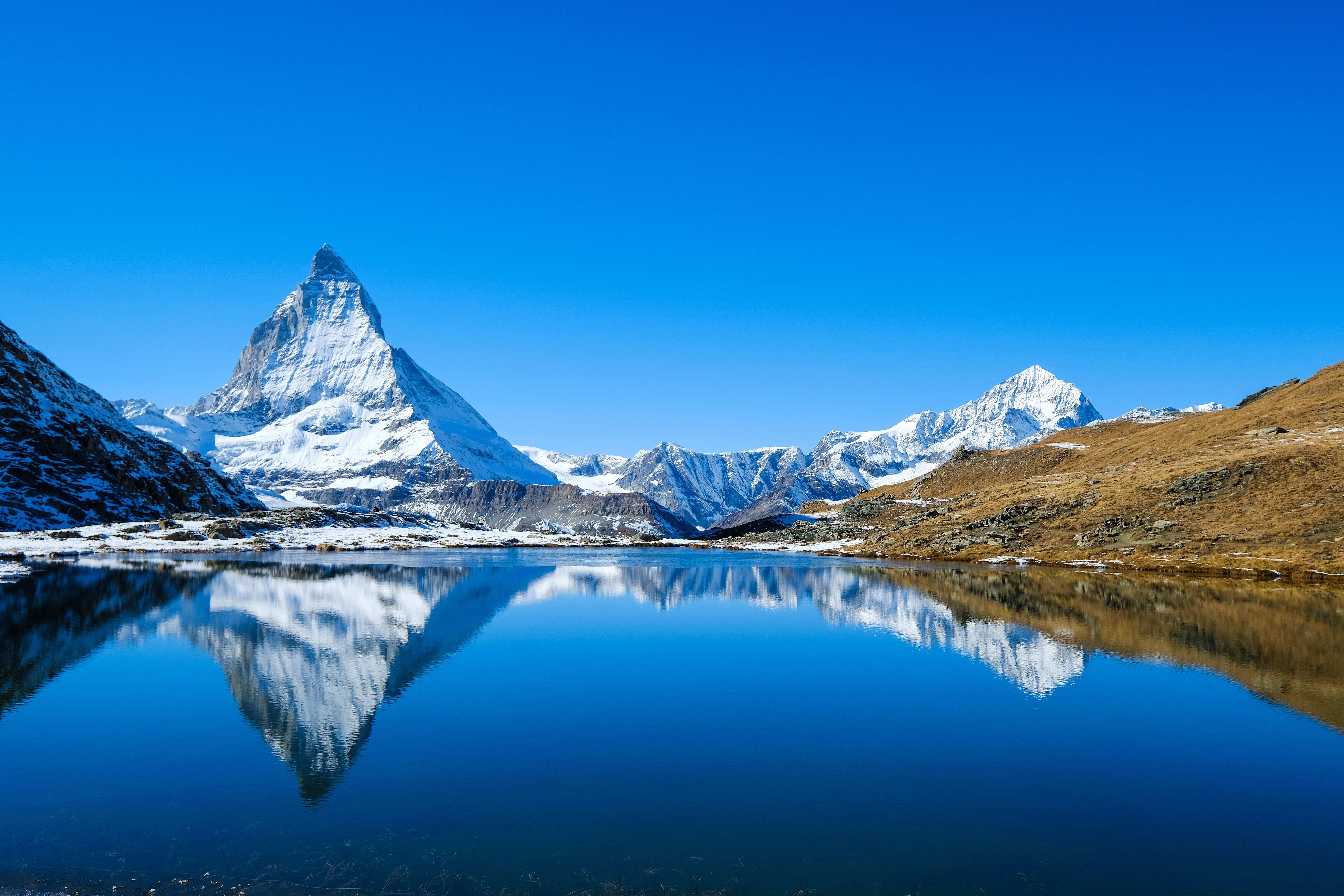 The Matterhorn summit is reflected in the glacial lake of the Swiss Alpine waters.