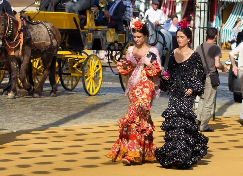 Women wearing traditional dresses in Seville, Spain.
