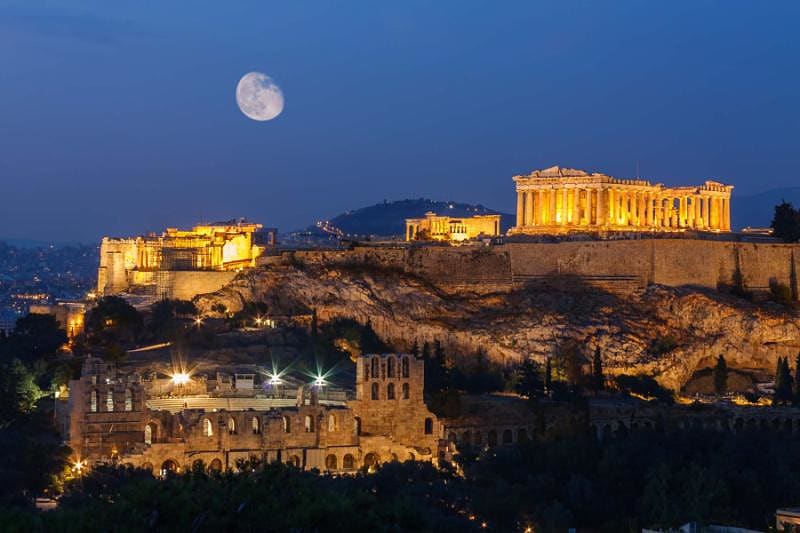 View of Acropolis, Athens, Greece at night with a full moon in the background