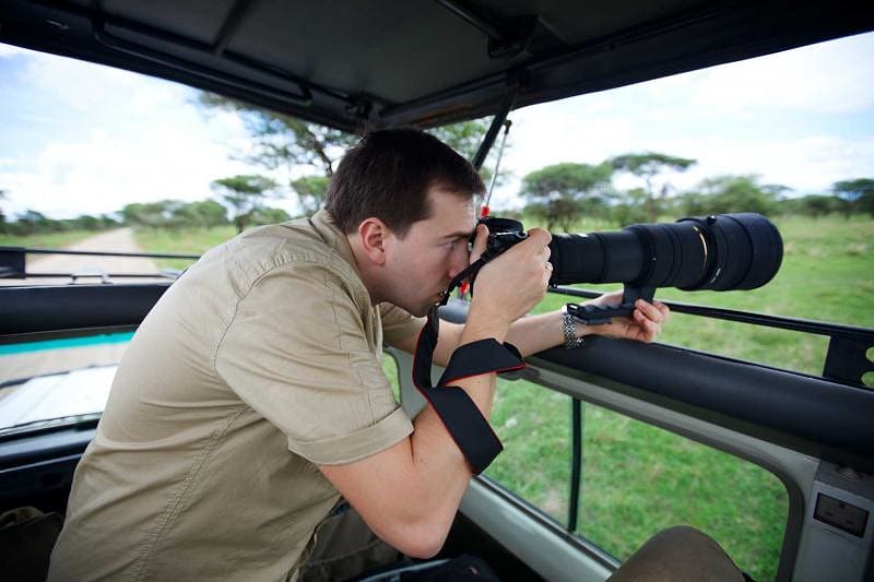 Photographer taking pictures on game drive in Tarangire National Park, Tanzania