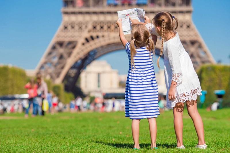 Little girls with a map of paris on the background of the Eiffel tower, Paris