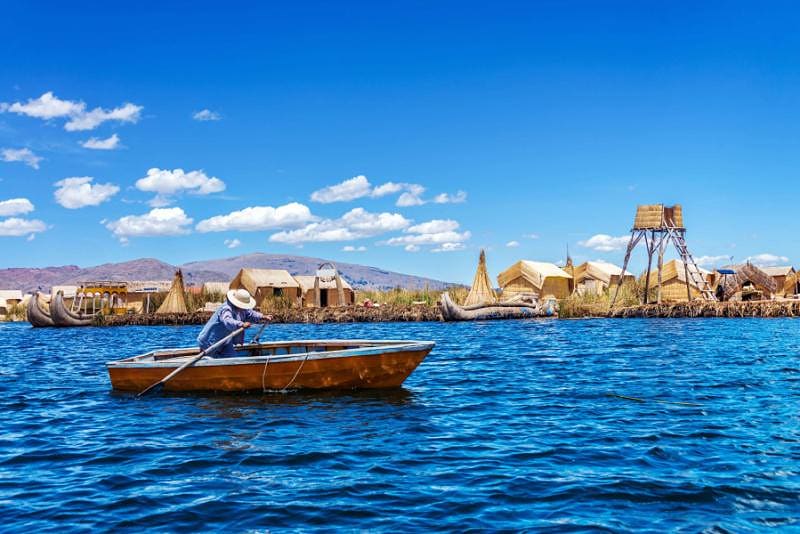 Peru & Machu Picchu Tour: Lima, Puno, Lake Titicaca, Cusco & Sacred Valley Rowboat and floating island on Lake Titicaca in Peru